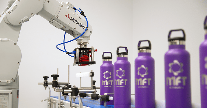 Mitsubhishi Robotic arm with suction cups and metal waterbottles on a conveyor